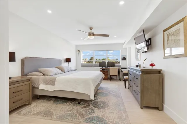 a bedroom with a bed a chandelier fan and a window
