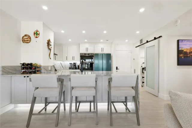 a view of kitchen with stainless steel appliances refrigerator stove dining table and chairs