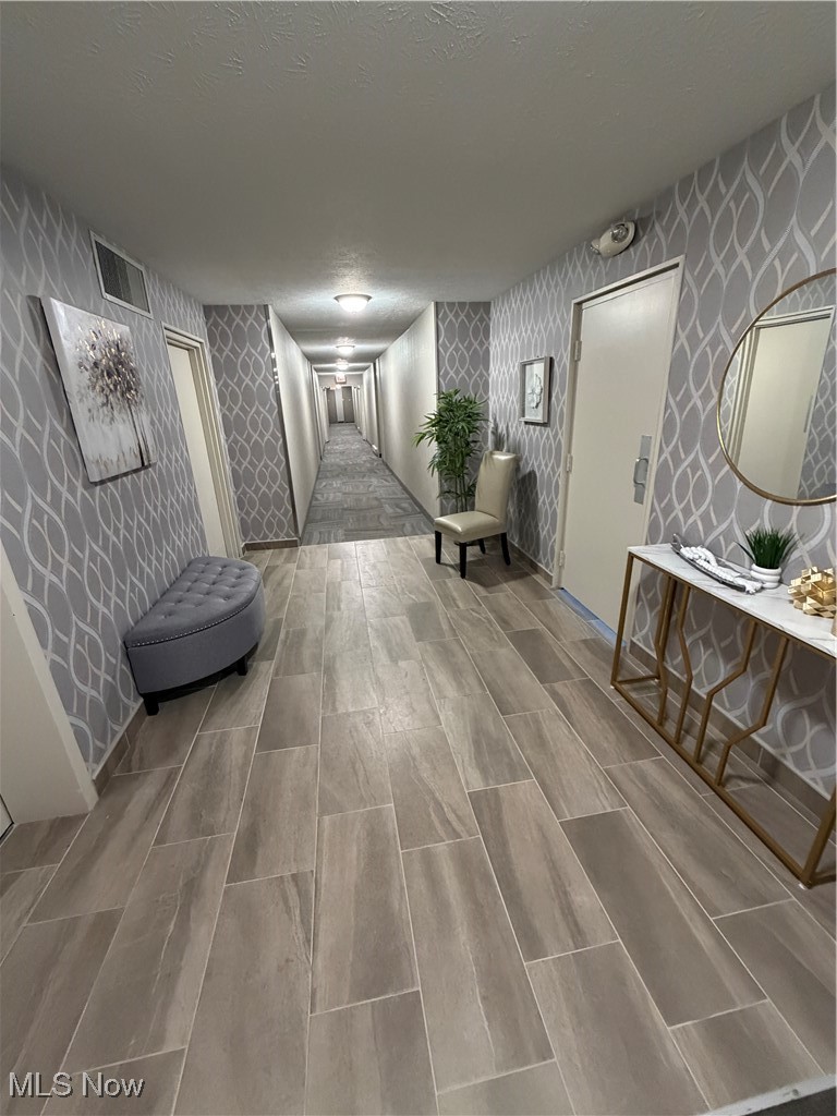 3066 Kent Road, Unit 407 Stow, OH 44224 - Photo 13 of 16 Hall featuring wood tiled floors, a textured ceiling, and wallpapered walls