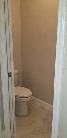 a white toilet sitting next to a shower