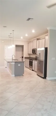 a large kitchen with stainless steel appliances granite countertop a stove top oven a refrigerator and white cabinets