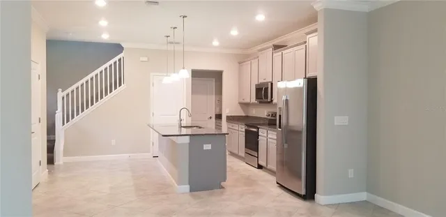 a kitchen with stainless steel appliances granite countertop a refrigerator a stove and a sink