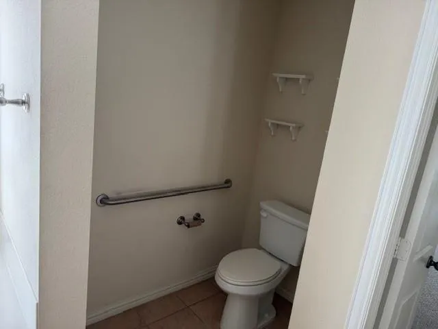 a white toilet sitting next to a shower