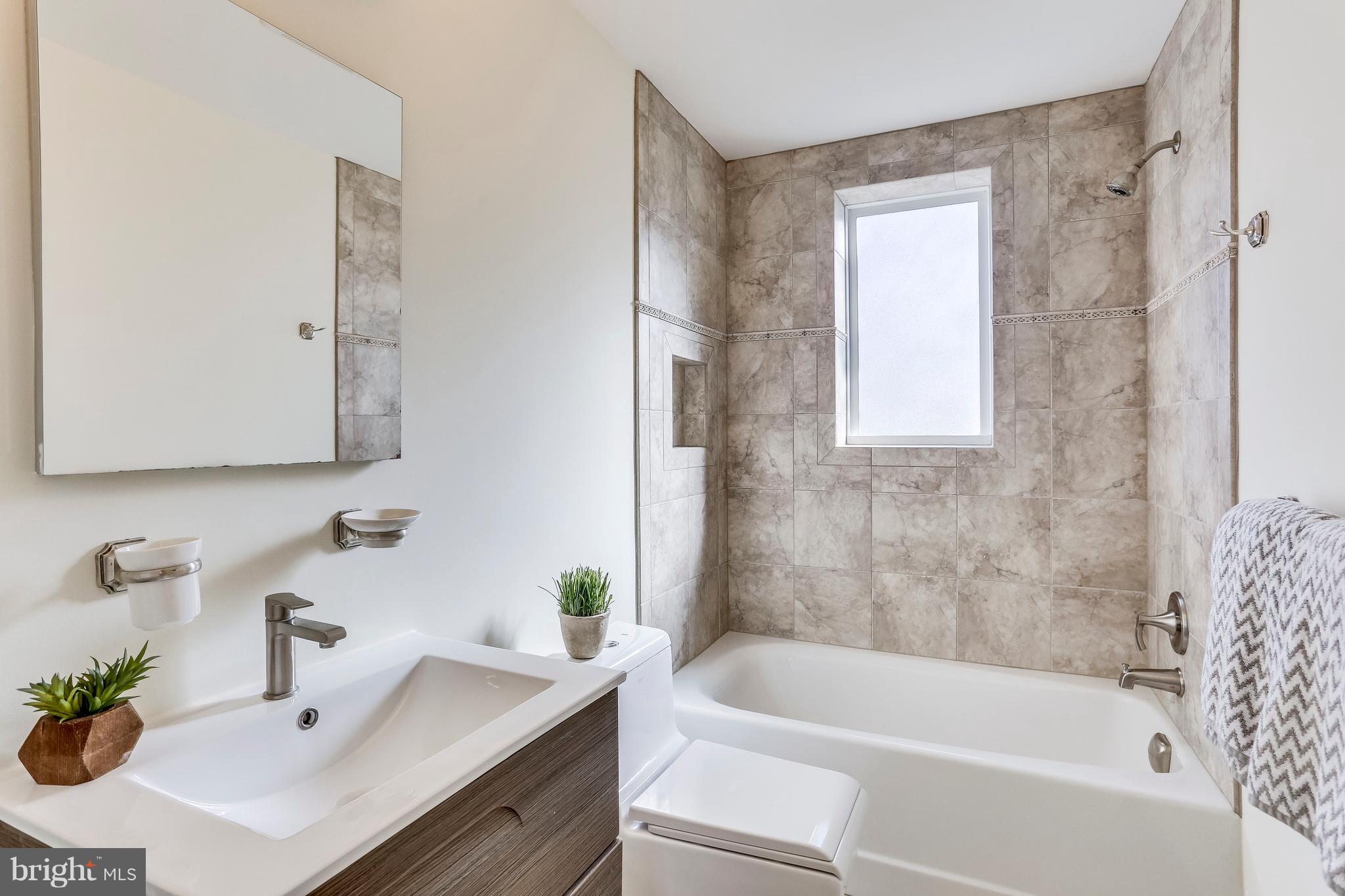 123 Tennessee Avenue Northeast Washington, DC 20002 - Photo 22 of 27 a white bath tub sitting next to a white sink and vanity
