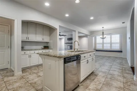 a kitchen with granite countertop a sink stove and cabinets
