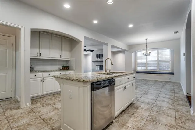 a kitchen with granite countertop a sink stove and cabinets