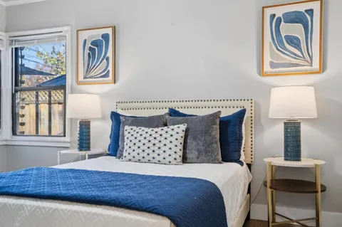 a bedroom with a bed and a lamp on dresser