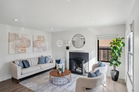 a living room with furniture a potted plant and a fireplace