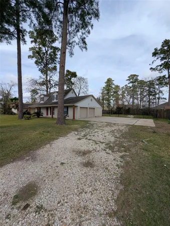 a view of a house with backyard and trees