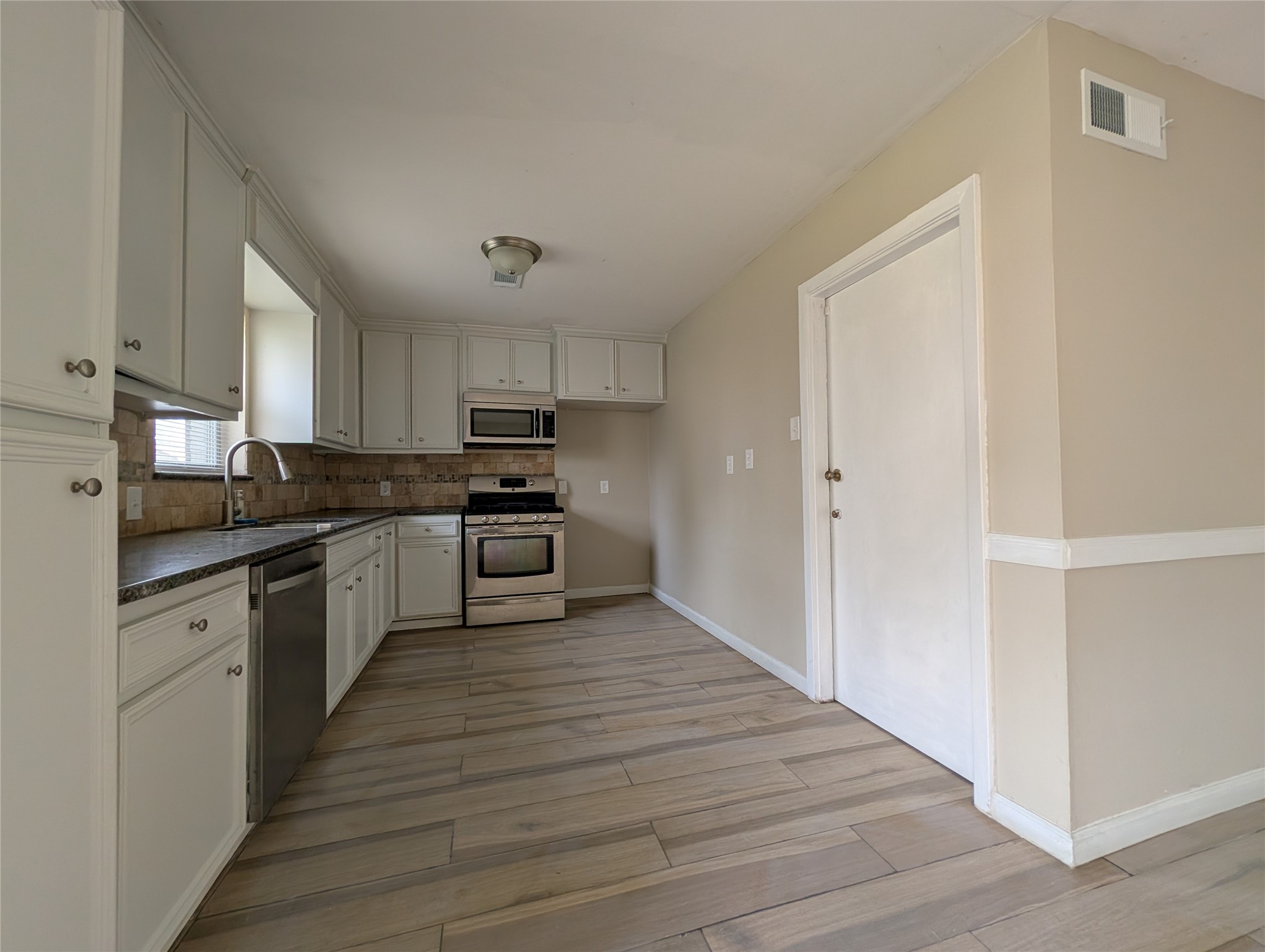 515 Broad Ripple Drive Houston, TX 77336 - Photo 5 of 21 a large kitchen with cabinets wooden floor and stainless steel appliances