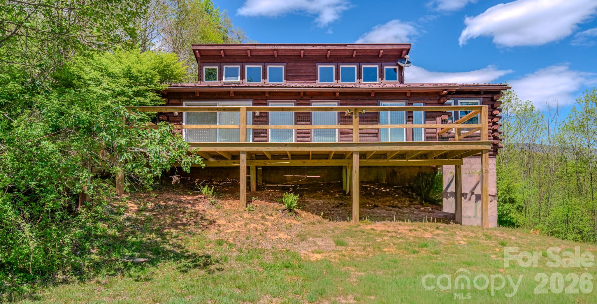 143 Gouge Cemetery Road Bakersville, NC 28705 - Photo 41 of 47 a view of a house with wooden deck and furniture
