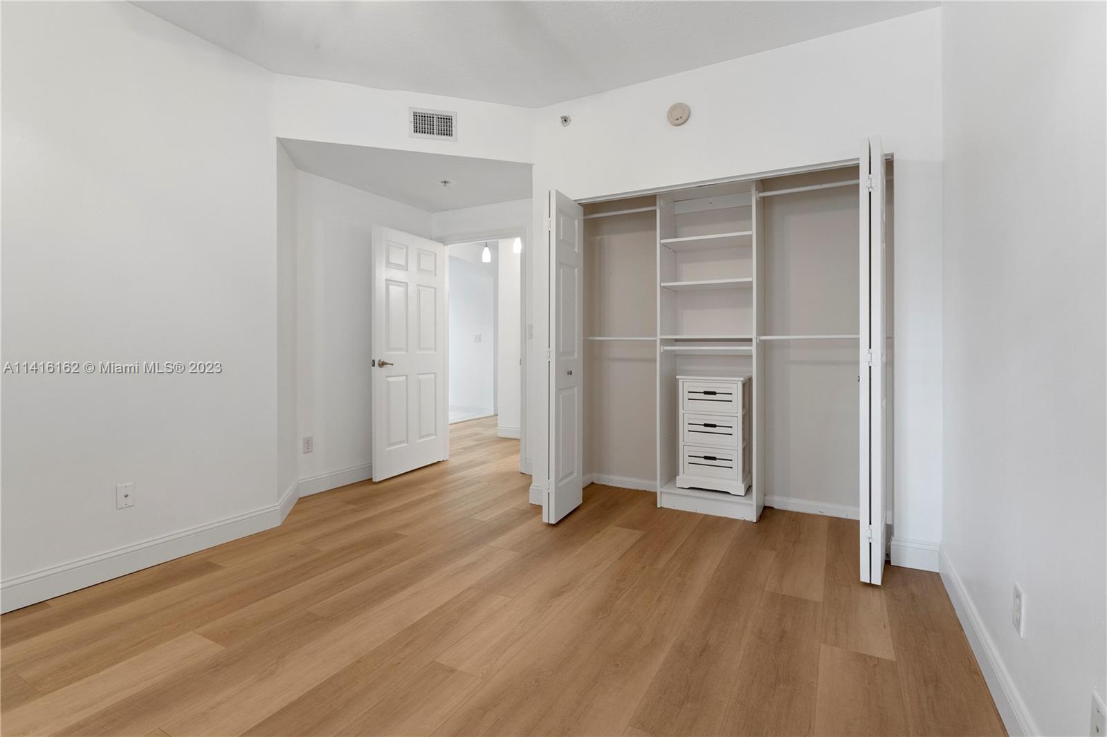22701 Camino Del Mar, Unit 25 Boca Raton, FL 33433 - Photo 14 of 19 a view of empty room with wooden floor and closet