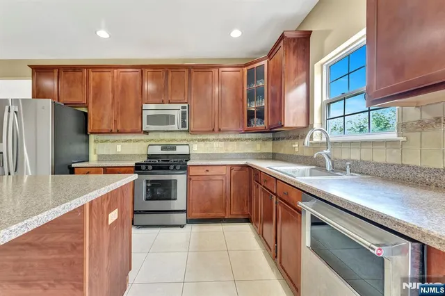 a kitchen with stainless steel appliances granite countertop a stove top oven a sink and dishwasher