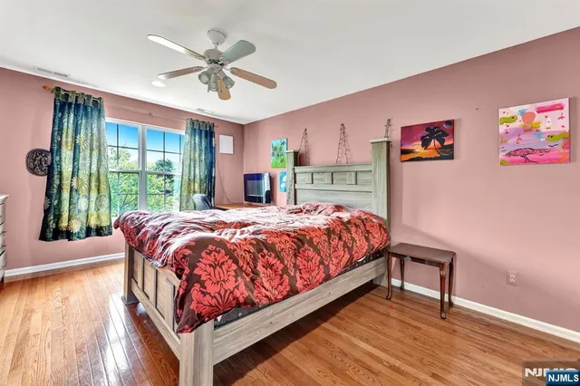 a bed sitting in a spacious bedroom next to a window