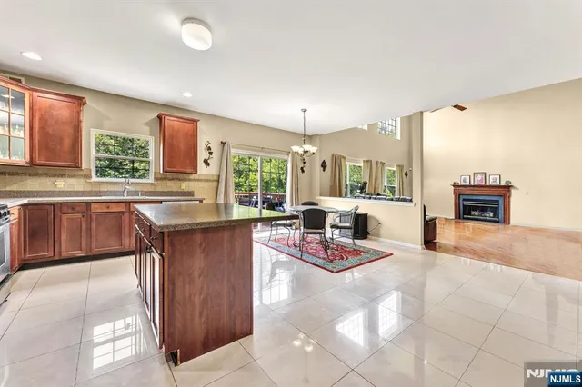 a kitchen with stainless steel appliances a stove a sink cabinets and living room view