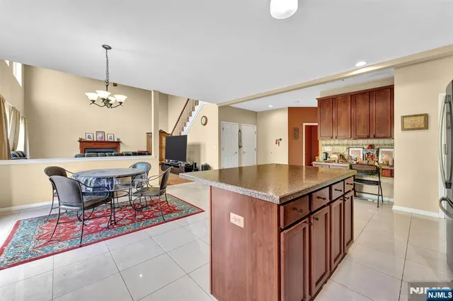a kitchen with granite countertop a stove a sink and a refrigerator