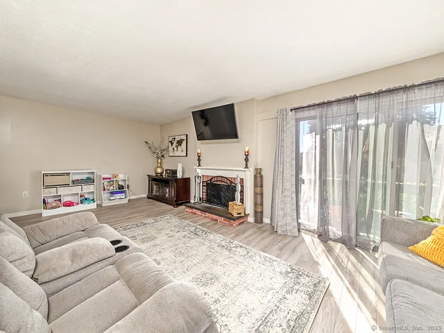a living room with furniture a fireplace and a flat screen tv