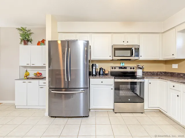 a kitchen with cabinets stainless steel appliances and a counter space
