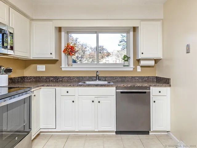 a kitchen with granite countertop a sink and a stove