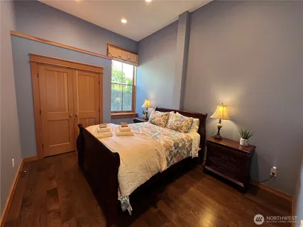 a bedroom with a bed and wooden floor