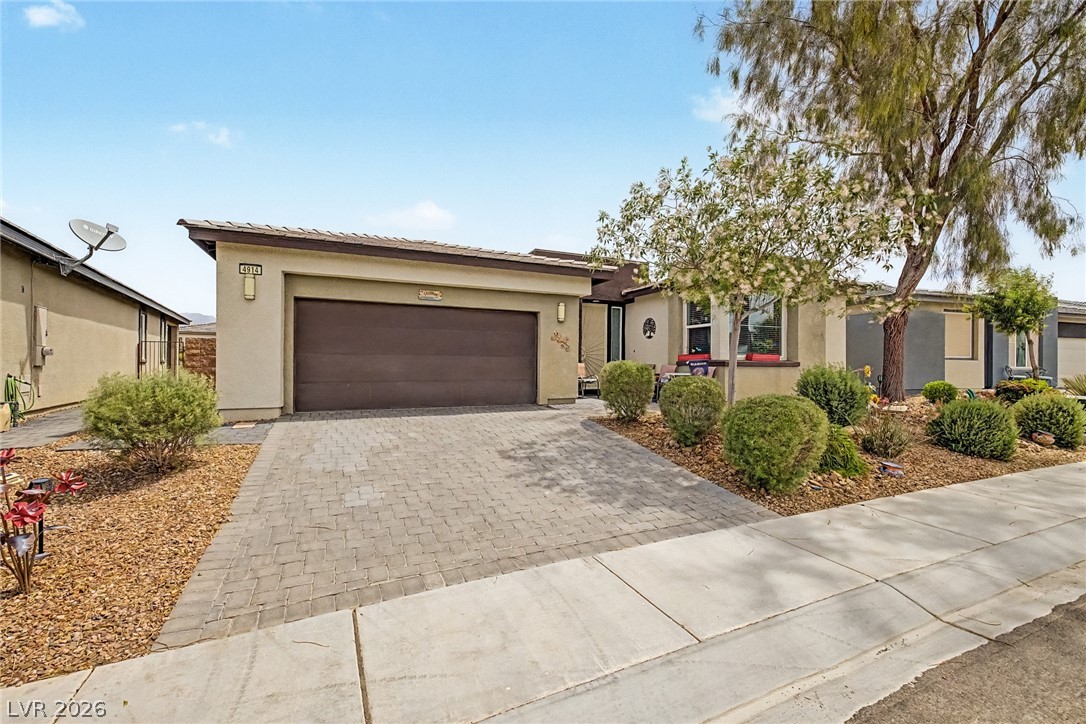 4914 East Beacon Ridge Drive Pahrump, NV 89061 - Photo 6 of 34 A neatly paved driveway leads to this charming single-story home with desert-friendly landscaping.