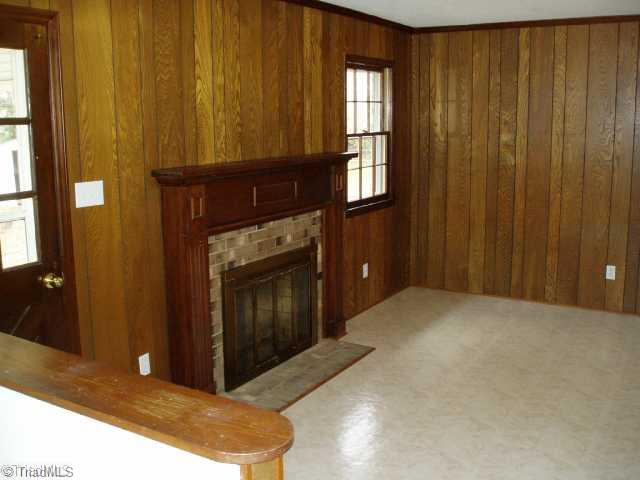 3218 Pine Needles Road High Point, NC 27265 - Photo 5 of 12 Den/Family/Great Room. Den with wood-burniing fireplace and new flooring and light fixtures.