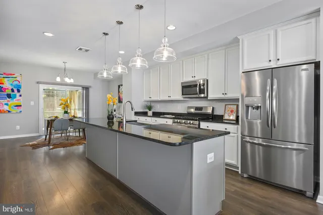 a living room with stainless steel appliances kitchen island granite countertop furniture and a kitchen view