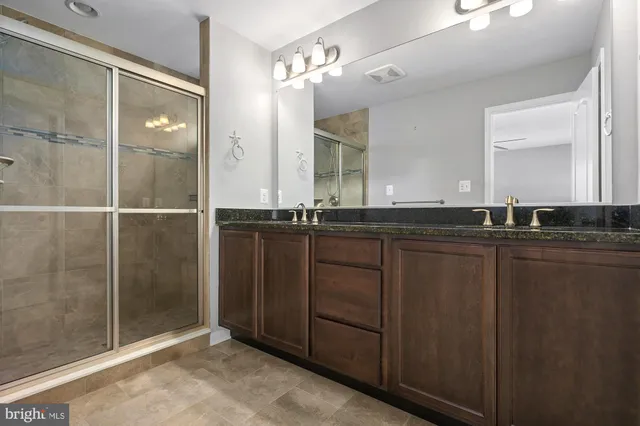a bathroom with a granite countertop shower and a sink