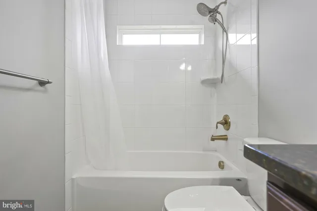 an empty room with a window and ceiling fan