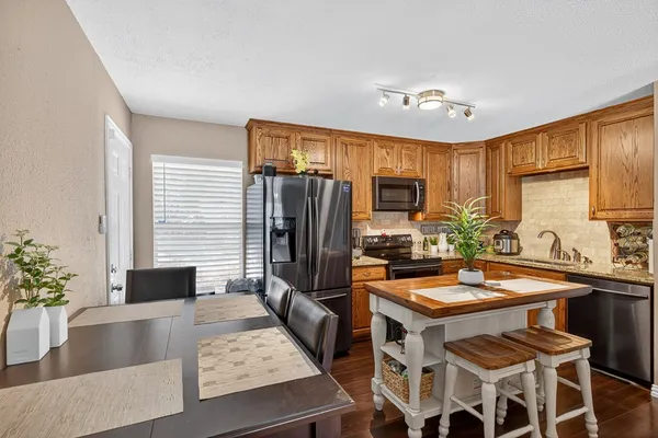 a kitchen with a table chairs stove and refrigerator