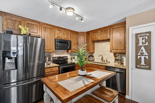 a kitchen with stainless steel appliances a refrigerator and a stove top oven