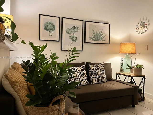a living room with furniture flowerpot and a lamp