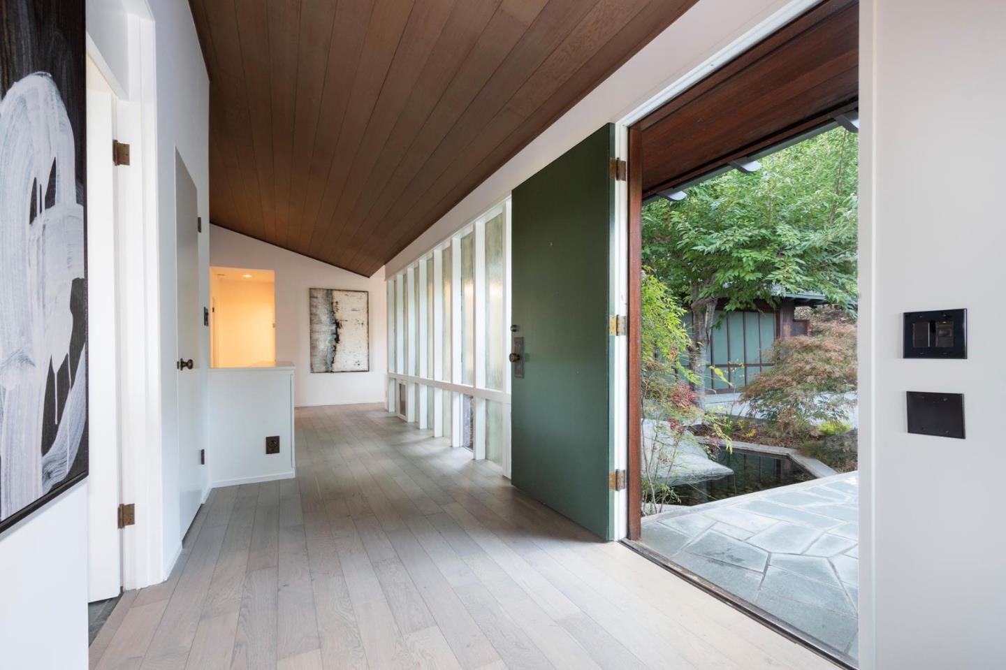 210 Hardwick Road Woodside, CA 94062 - Photo 5 of 29 a view of a hallway with wooden floor and a living room
