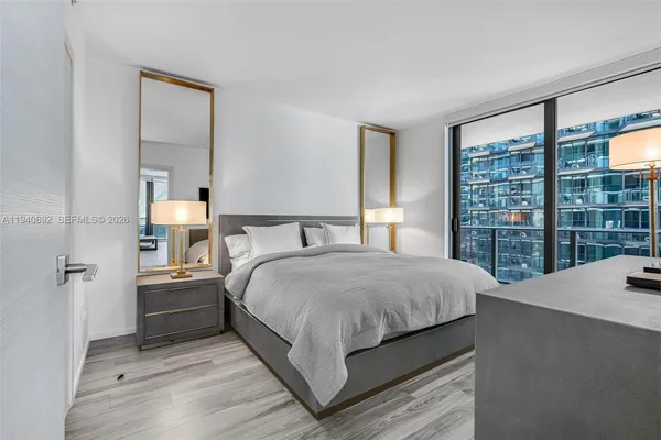 a bedroom with a large bed and a large window