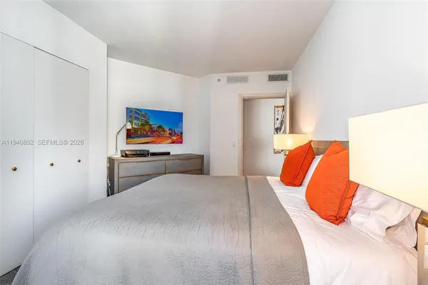 a bedroom with a bed and a painting on the wall