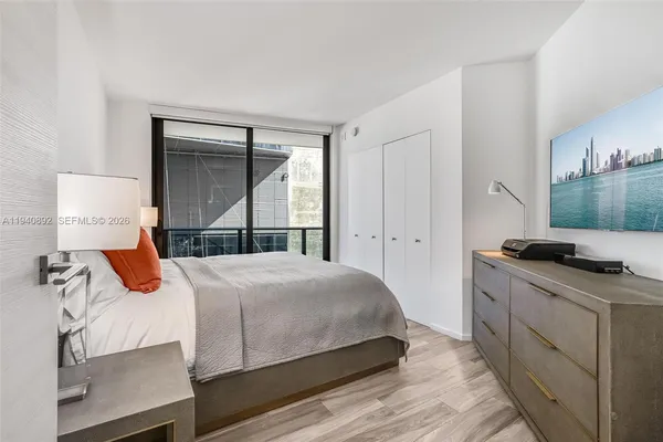 a bedroom with a bed and a large window