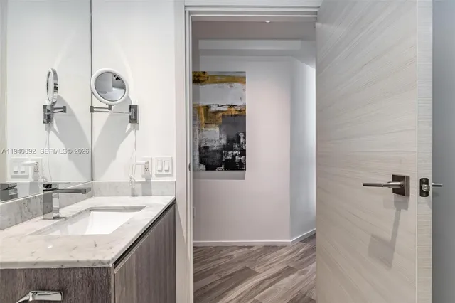a bathroom with a granite countertop sink and a mirror