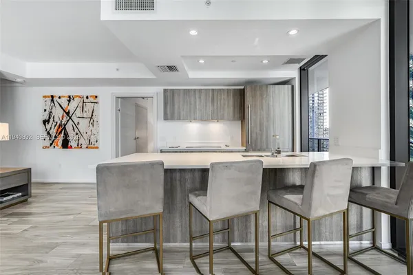 a kitchen with granite countertop a table chairs stove and wooden floor