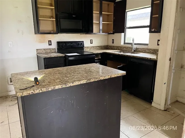 a kitchen with stainless steel appliances granite countertop a sink stove and microwave