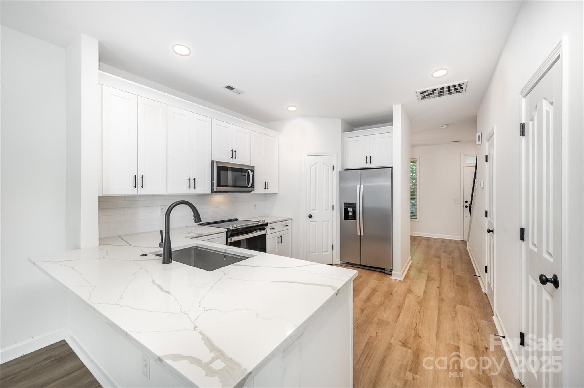 a kitchen with a refrigerator a sink and cabinets