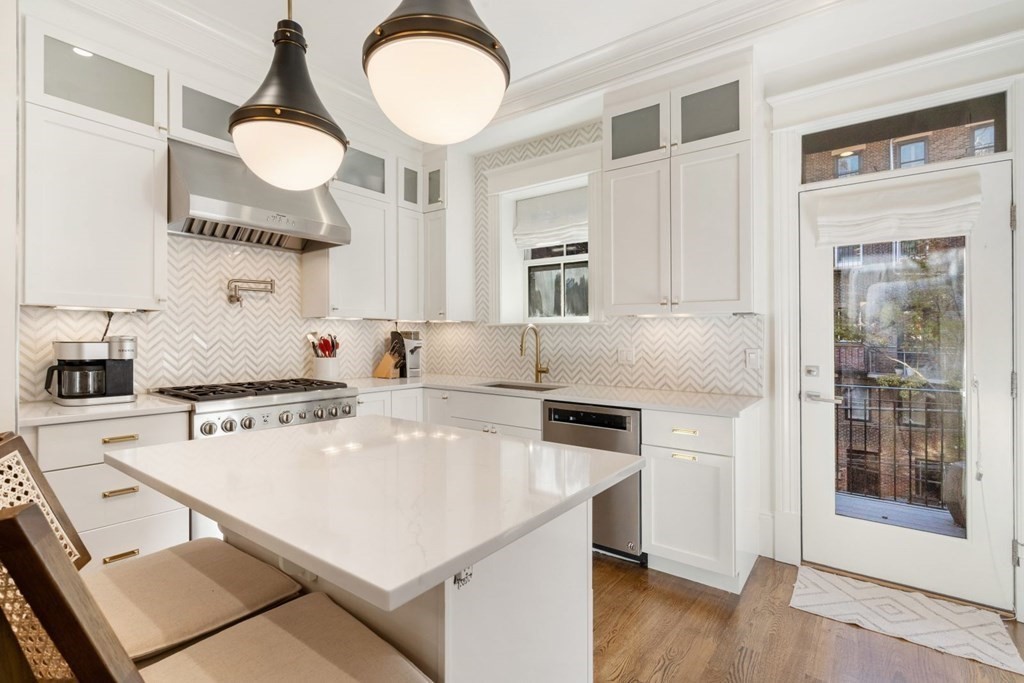 34 Dwight Street, Unit 1 Boston, MA 02118 - Photo 12 of 40 a kitchen with a refrigerator a stove a sink and a dining table with wooden floor