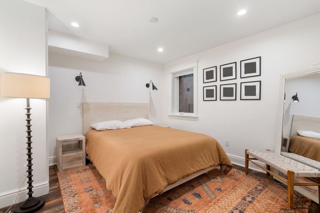 34 Dwight Street, Unit 1 Boston, MA 02118 - Photo 29 of 40 a bedroom with a bed wooden floor and a table