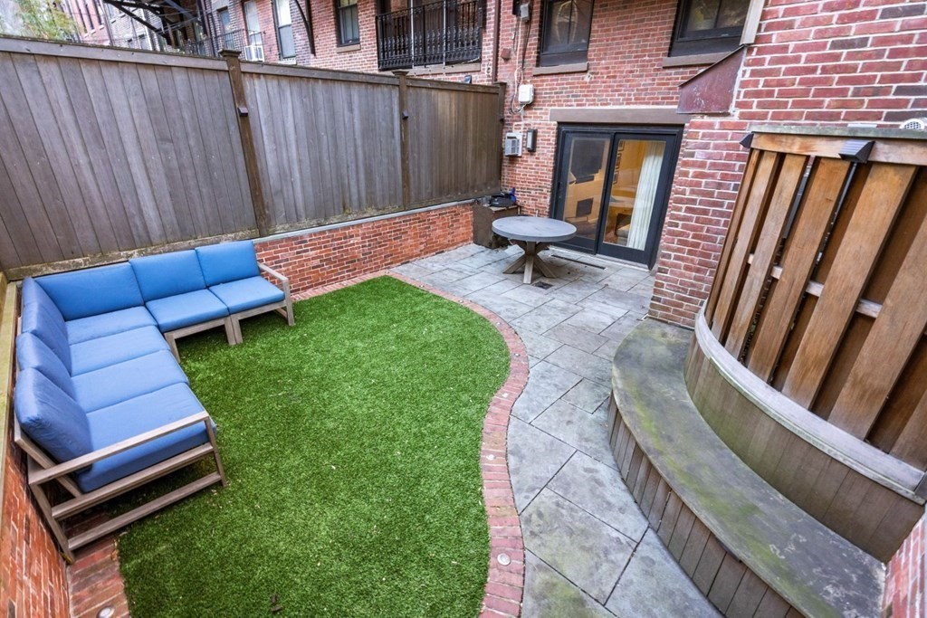 34 Dwight Street, Unit 1 Boston, MA 02118 - Photo 36 of 40 a backyard of a house with chairs and a fire pit