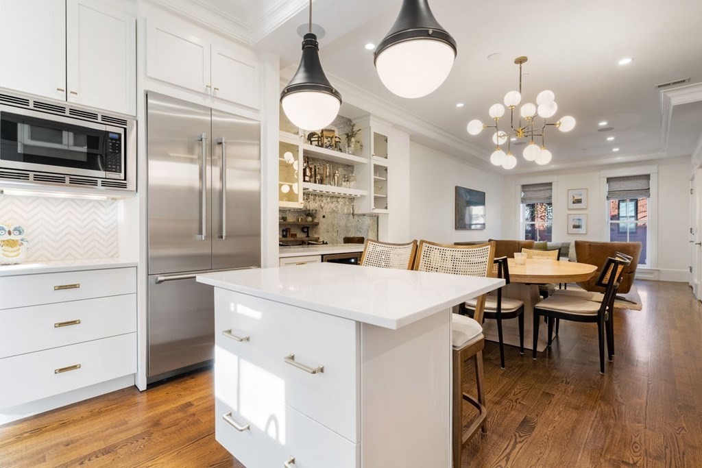 34 Dwight Street, Unit 1 Boston, MA 02118 - Photo 9 of 40 a open kitchen with stainless steel appliances kitchen island granite countertop a stove refrigerator and dining table with wooden floor