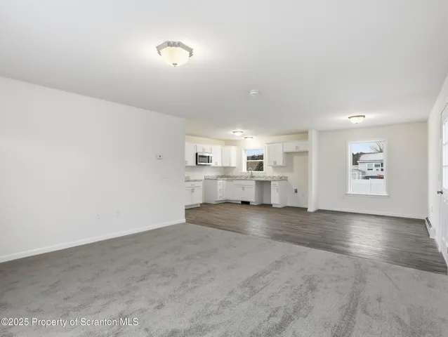 a kitchen with stainless steel appliances granite countertop a stove top oven a sink and white cabinets