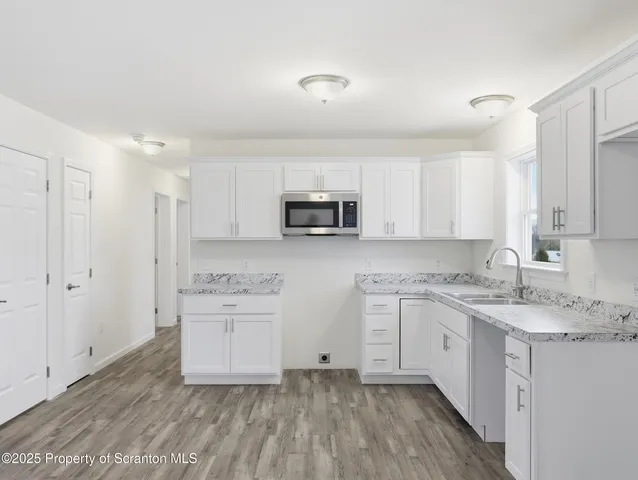 a kitchen with a sink cabinets and wooden floor