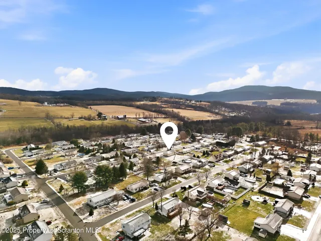 a view of a house with a yard covered in snow