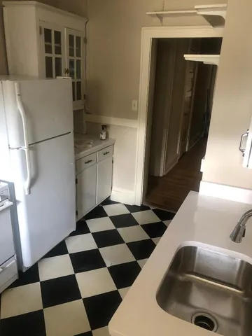 an empty room with wooden floor fireplace and windows