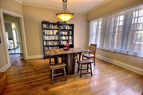 an empty room with wooden floor fireplace and windows