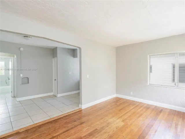 a large white kitchen with granite countertop a sink and dishwasher with a large window